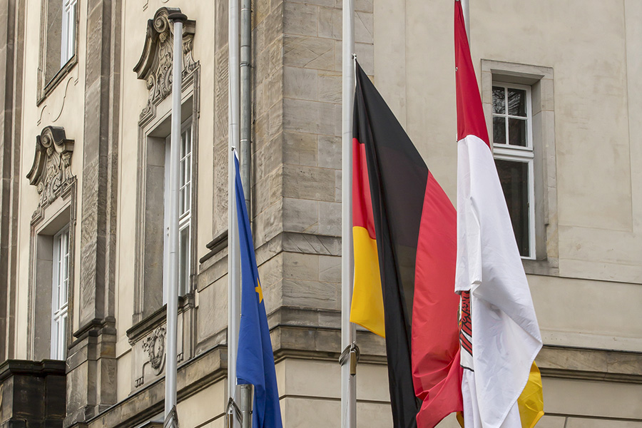 Europa-, Deutschland- und Brandenburg-Flagge auf Halbmast im Ehrenhof mit Blick auf das Viadrina Hauptgebäude