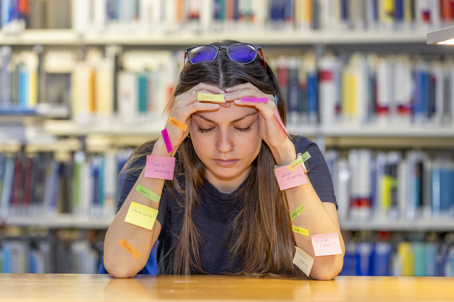 müde Studentin mit Aufklebern an Händen und Armen