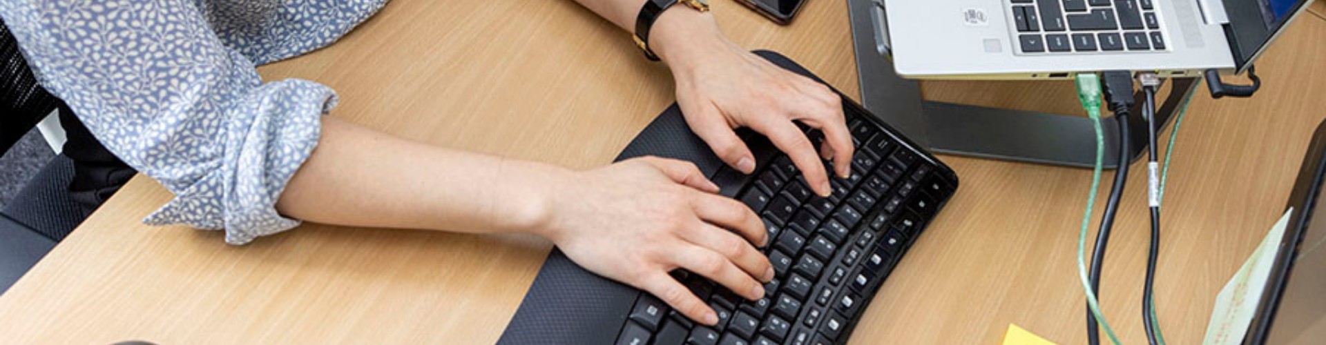 Person tippt auf einer Tastatur in einem Viadrina Büro